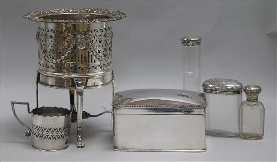 A silver plated bottle coaster, on reeded legs with paw feet, a plated biscuit box and three toilet jars a cup holder